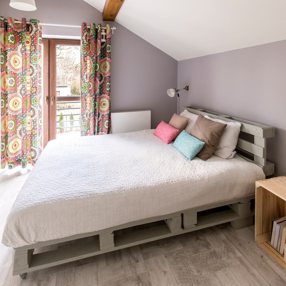 Łóżko z palet z materacem i poduszkami