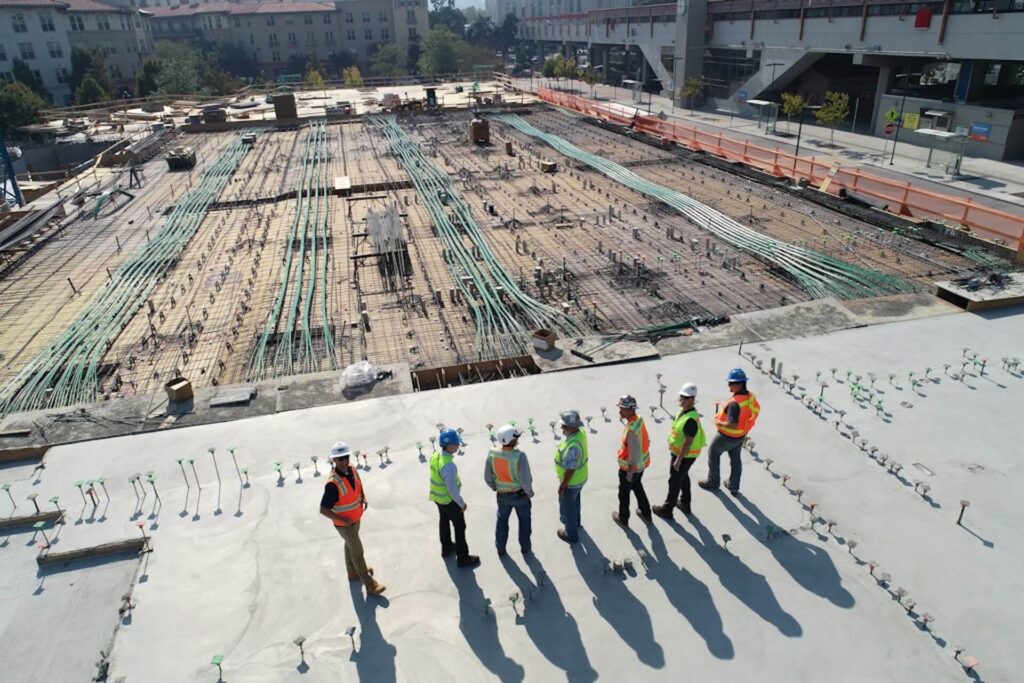 pracownicy podczas budowy hali na betonowej płycie
