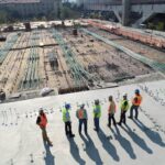 pracownicy podczas budowy hali na betonowej płycie